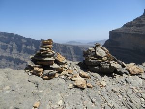 two cairns of rocks are piled on the edge of the path of the balcony walk at Jebel Shams