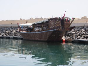 A traditional dhow harboured at Bandar Al Rowdha marina