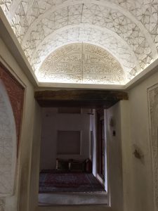 The view along a corridor in Jabreen Castle with an intricately carved ceiling