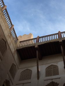 A view from inside the courtyard of Jabreen castle. A small crescent moon cab be seen in the blue sky